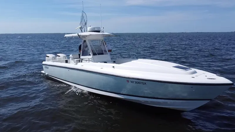 Slide: The Image of 1998 Intrepid 327 Cuddy boat cruising on open water under clear skies. - 8