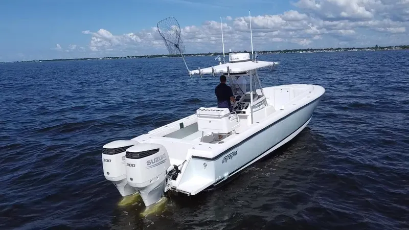 Slide: The Image of 1998 Intrepid 327 Cuddy boat on open water with dual Suzuki engines. - 9