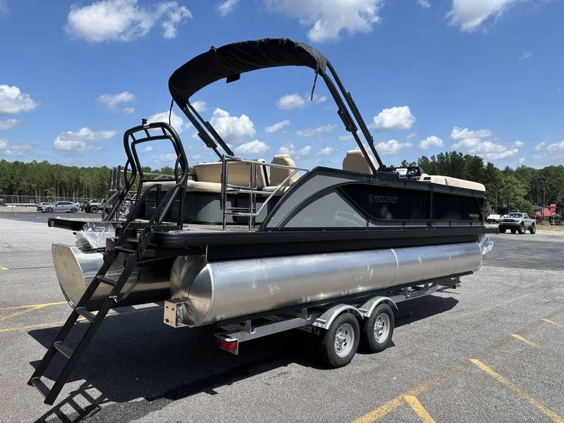 Slide: The Image of 2026 Godfrey SWEETWATER 2286 SFL pontoon boat on trailer, parked outdoors under blue sky. - 1
