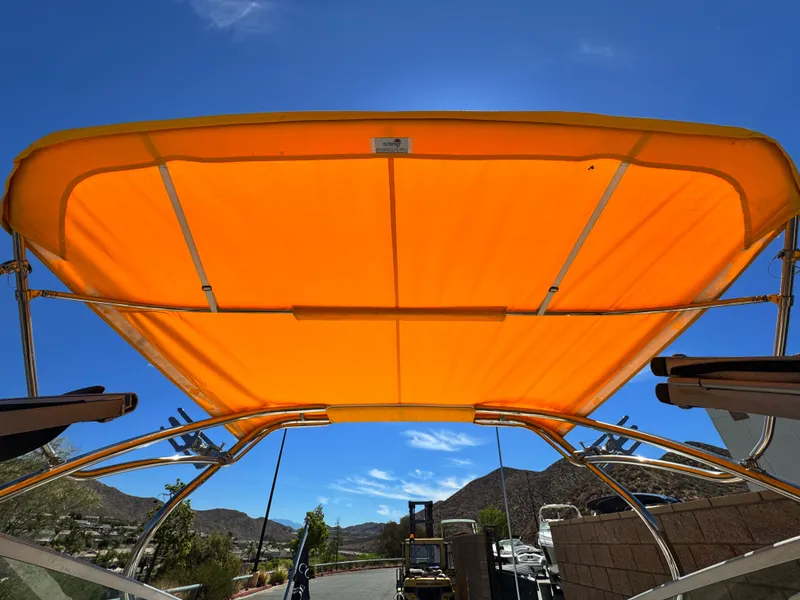Slide: The Image of Orange canopy on a 2006 Cobalt 246 boat against a clear blue sky. - 11