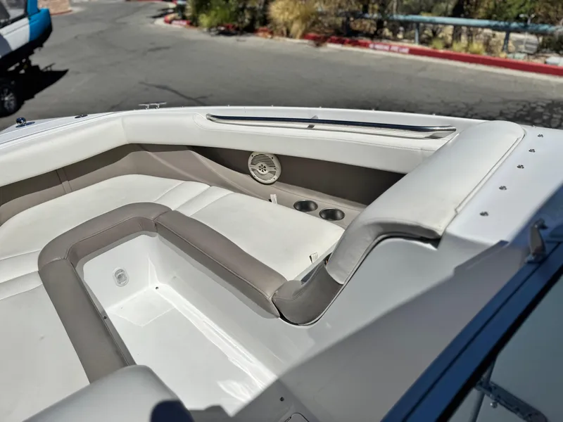 Slide: The Image of 2006 Cobalt 246 boat interior with white and gray seating, cup holders, and speaker. - 16