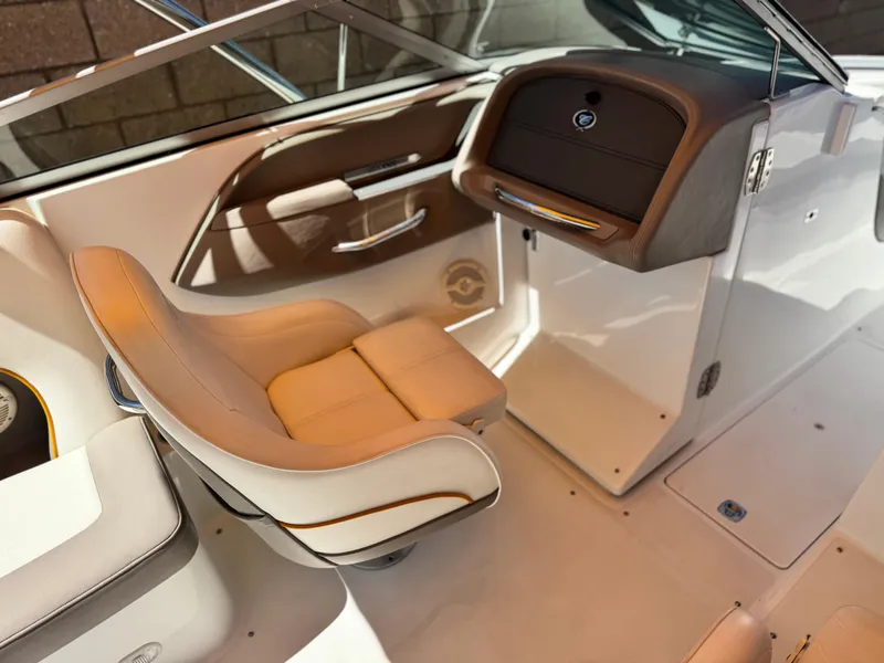 Slide: The Image of 2006 Cobalt 246 boat interior with beige seating and sleek dashboard design. - 24