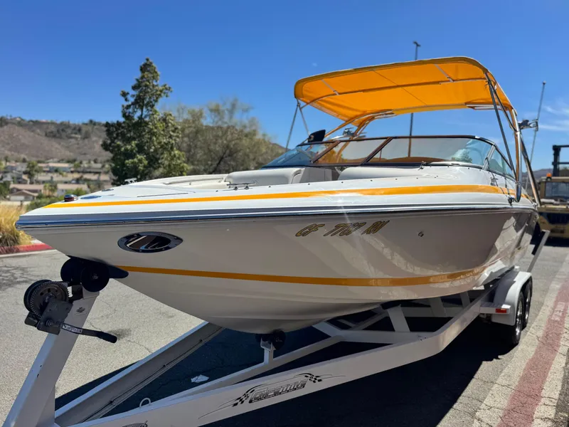 Slide: The Image of 2006 Cobalt 246 boat with yellow canopy on trailer, parked outdoors. - 3