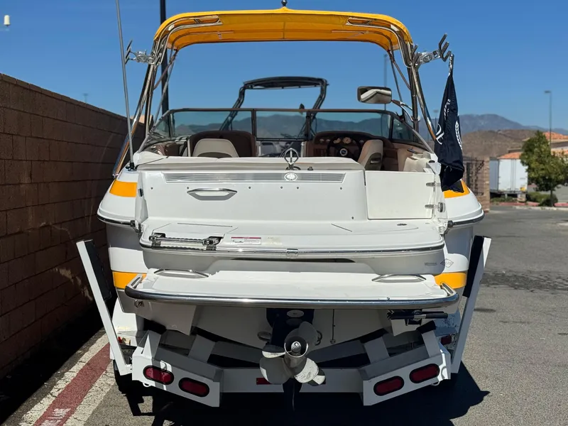 Slide: The Image of 2006 Cobalt 246 boat with yellow canopy, parked on a sunny day. - 4