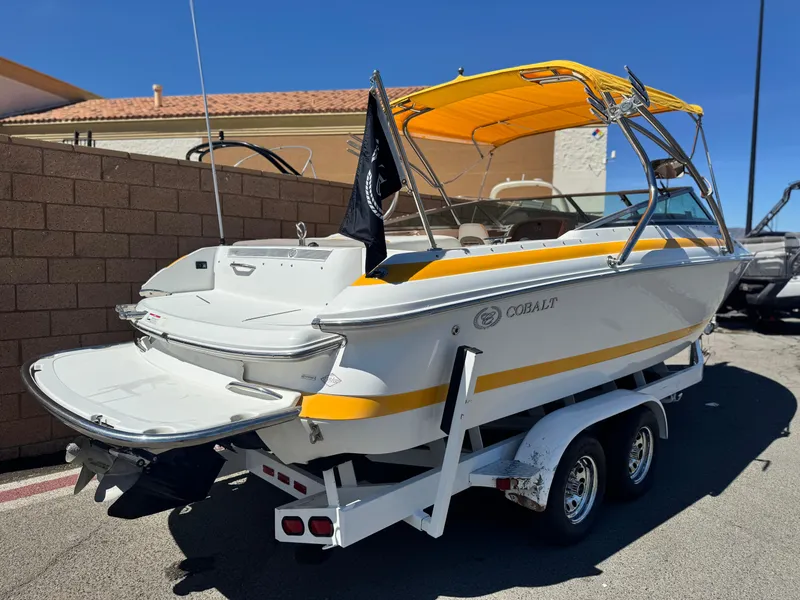 Slide: The Image of 2006 Cobalt 246 boat with yellow canopy on trailer, parked outdoors. - 5