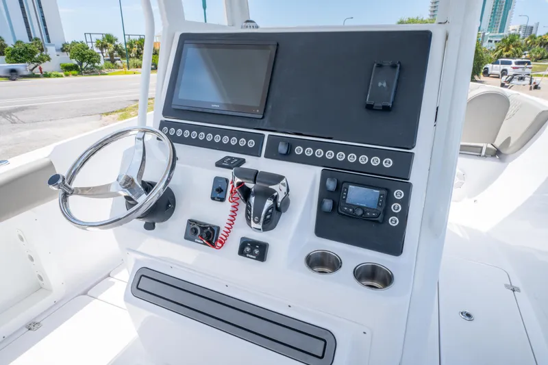 Slide: The Image of 2024 Savannah 2900 Offshore boat dashboard with steering wheel and navigation controls. - 11