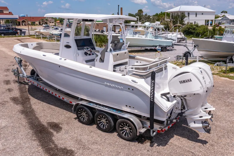 Slide: The Image of 2024 Savannah 2900 Offshore boat on trailer with Yamaha engines, parked in marina. - 3