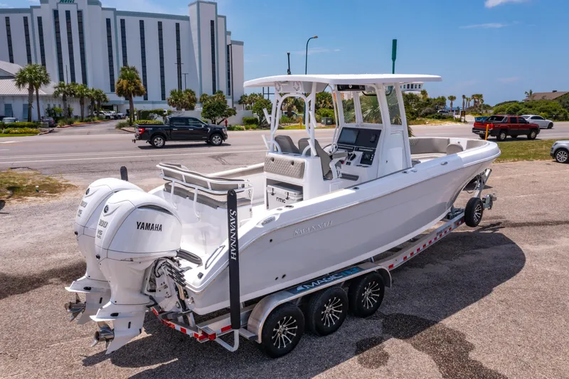 Slide: The Image of 2024 Savannah 2900 Offshore boat on trailer with dual Yamaha engines, parked near a road. - 4