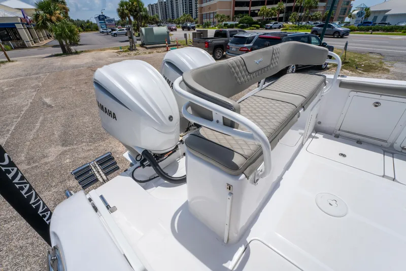 Slide: The Image of 2024 Savannah 2900 Offshore boat with Yamaha engines and cushioned seating, parked near a road. - 7