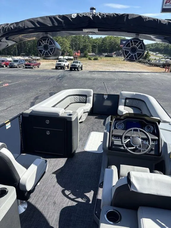 Slide: The Image of 2026 Godfrey AquaPatio 255 ULC pontoon boat interior with modern seating and dashboard. - 26