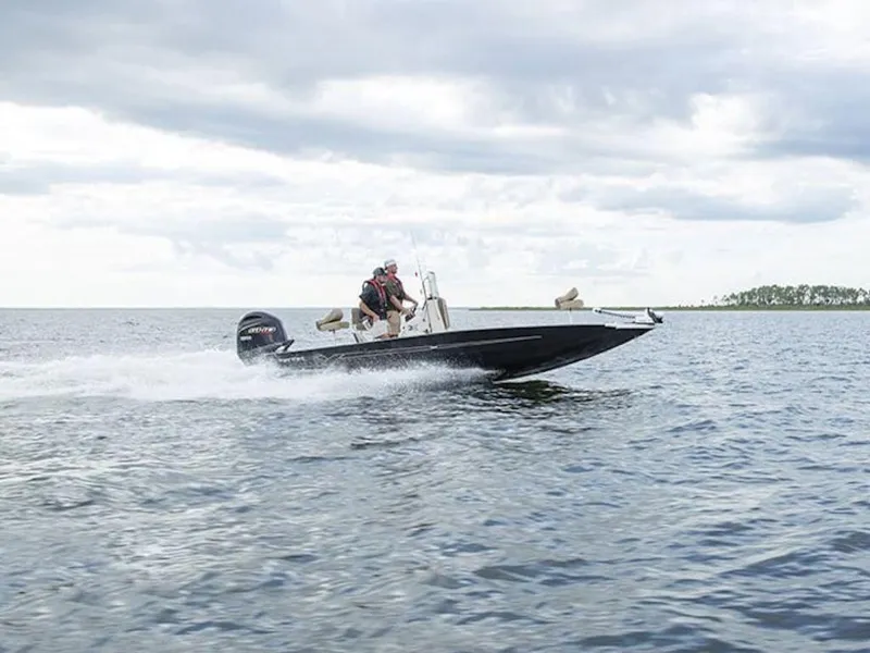 Slide: The Image of 2026 Xpress H22 Bay boat speeding on open water under cloudy sky. - 0