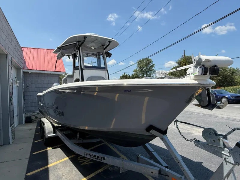 Slide: The Image of 2022 NauticStar 2602 Legacy boat on trailer, parked outside under clear blue sky. - 10
