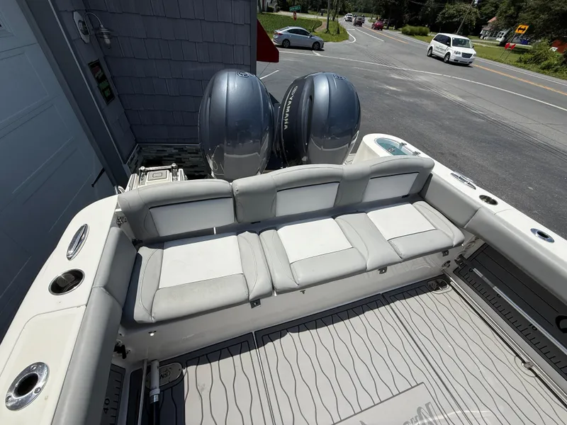 Slide: The Image of 2022 NauticStar 2602 Legacy boat with dual Yamaha engines, docked near a road. - 15