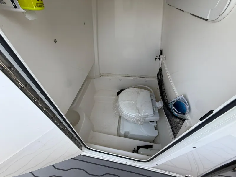 Slide: The Image of 2022 NauticStar 2602 Legacy boat interior with compact marine toilet. - 20