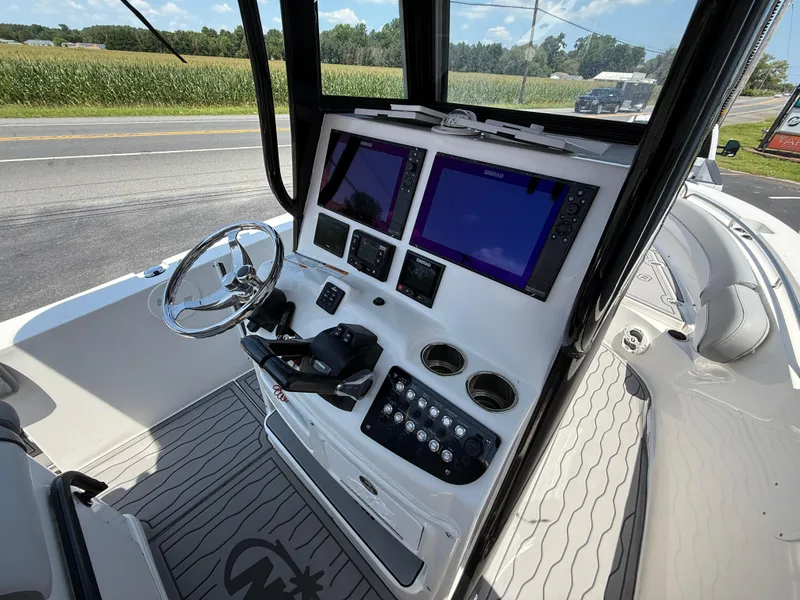 Slide: The Image of 2022 NauticStar 2602 Legacy boat dashboard with dual screens and steering wheel. - 22