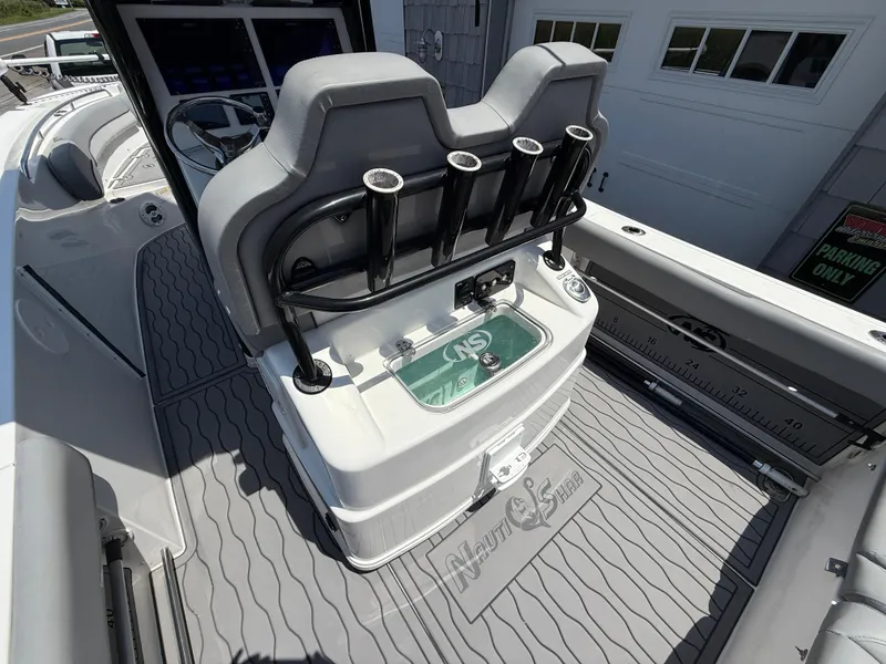 Slide: The Image of 2022 NauticStar 2602 Legacy boat interior with rod holders and storage compartment. - 25