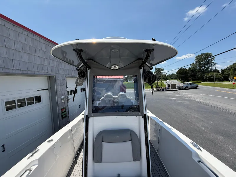 Slide: The Image of 2022 NauticStar 2602 Legacy boat, view of helm and T-top, parked near garage. - 33