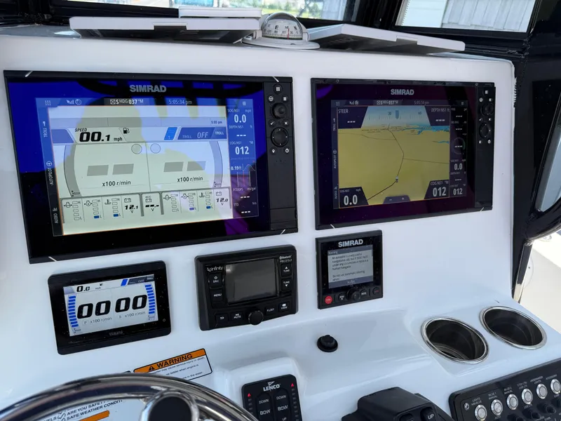Slide: The Image of Control panel of 2022 NauticStar 2602 Legacy boat with Simrad navigation displays. - 35
