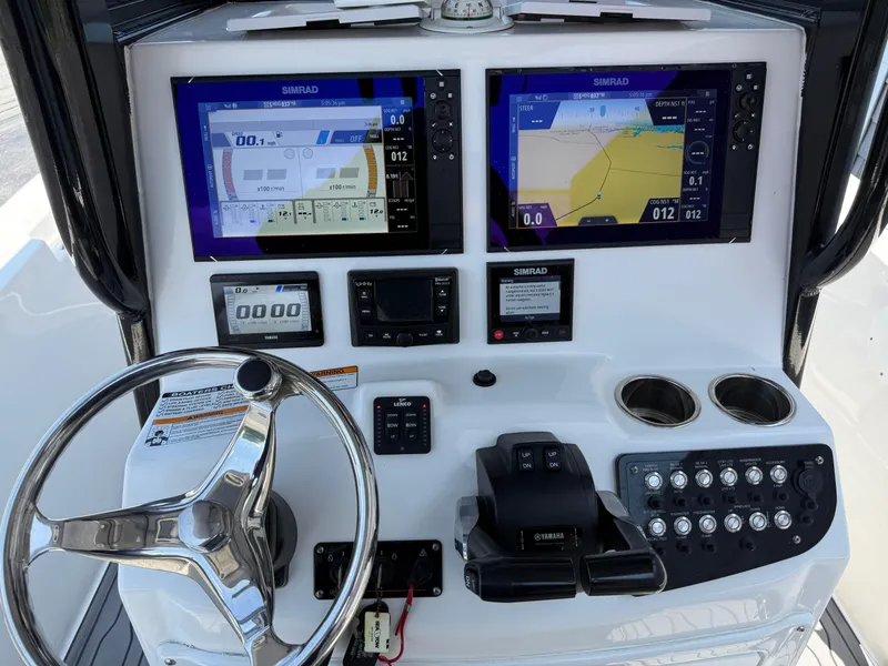 Slide: The Image of 2022 NauticStar 2602 Legacy boat dashboard with Simrad displays and Yamaha controls. - 36