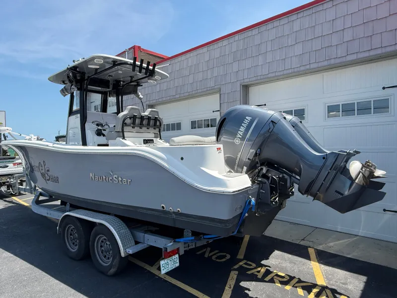 Slide: The Image of 2022 NauticStar 2602 Legacy boat on trailer, parked outside a garage. - 5