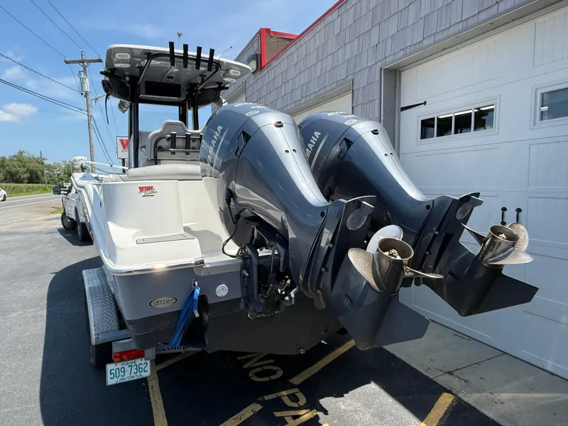 Slide: The Image of 2022 NauticStar 2602 Legacy boat with dual Yamaha outboard motors parked outside. - 7
