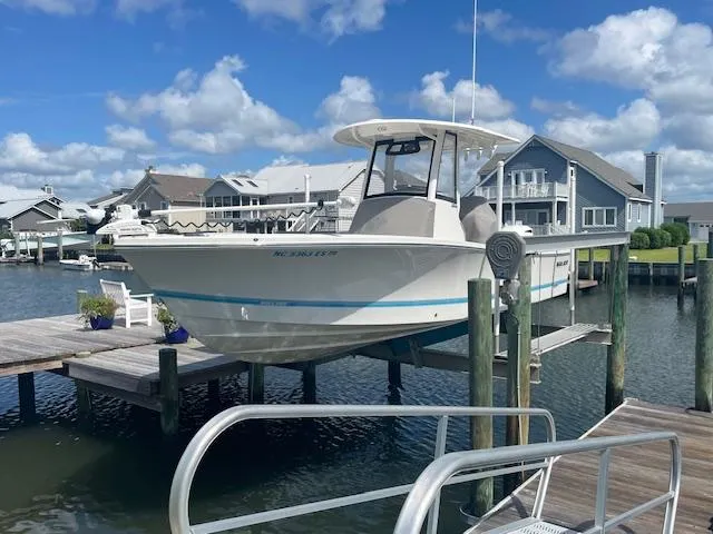 The Image of 2021 Regulator 26XO boat docked at a marina with waterfront homes in the background. - 0