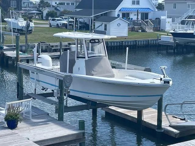 Slide: The Image of 2021 Regulator 26XO boat docked in a marina, featuring a sleek white design. - 1