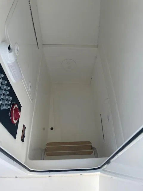 Slide: The Image of Interior view of 2021 Regulator 26XO boat compartment, featuring control panel and storage space. - 12