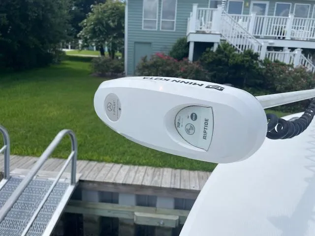 Slide: The Image of Minn Kota Riptide motor on 2021 Regulator 26XO boat docked near a house. - 13
