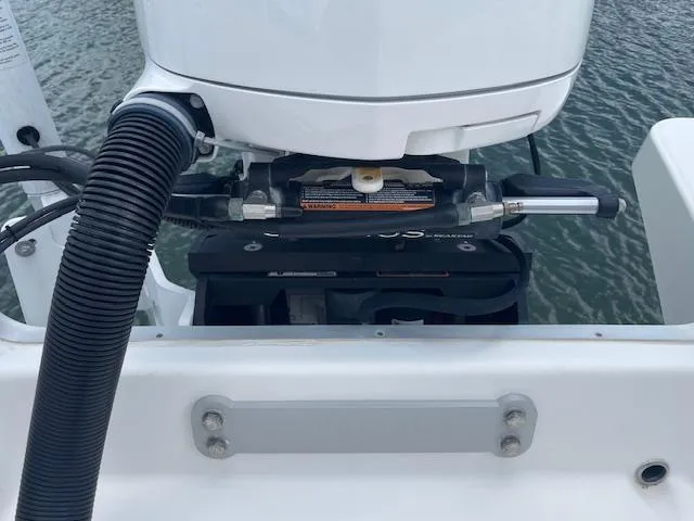 Slide: The Image of 2021 Regulator 26XO boat engine detail with hydraulic steering system, docked on water. - 15