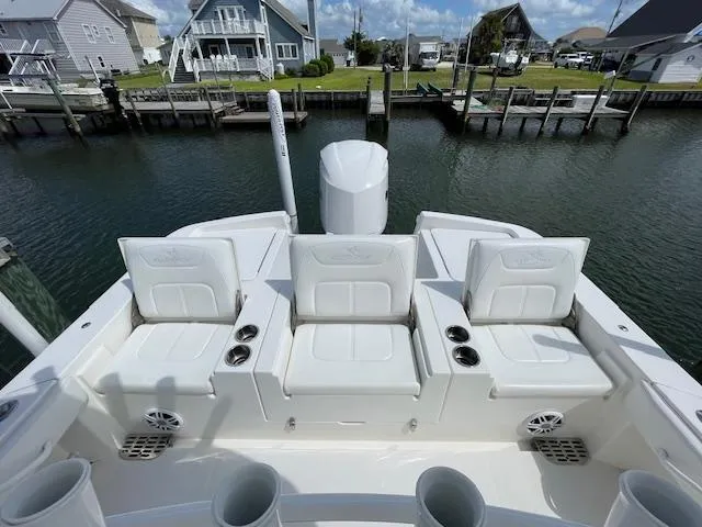 Slide: The Image of 2021 Regulator 26XO boat with white seating, docked near waterfront homes. - 8
