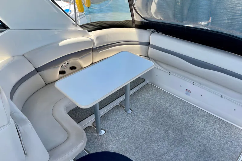 Slide: The Image of 2005 Chaparral Signature 350 interior with white seating and table, showcasing luxury boat design. - 11