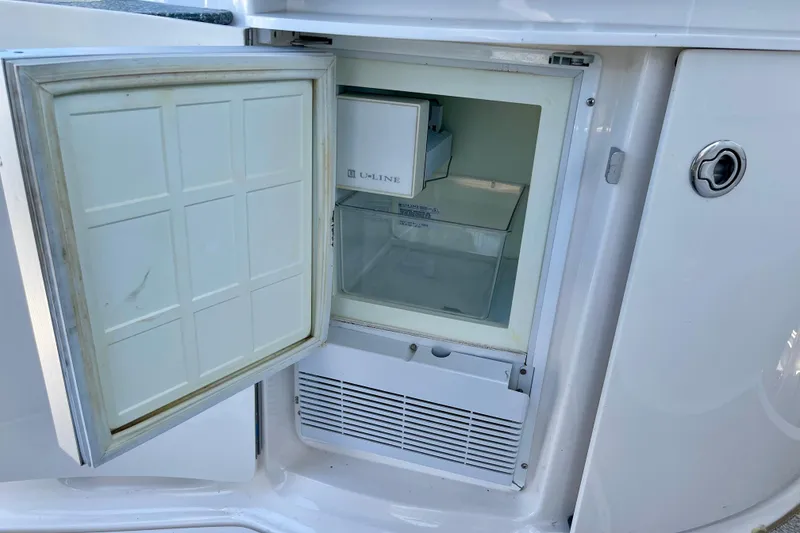 Slide: The Image of Open mini fridge on 2005 Chaparral Signature 350 boat, showing interior shelves. - 19
