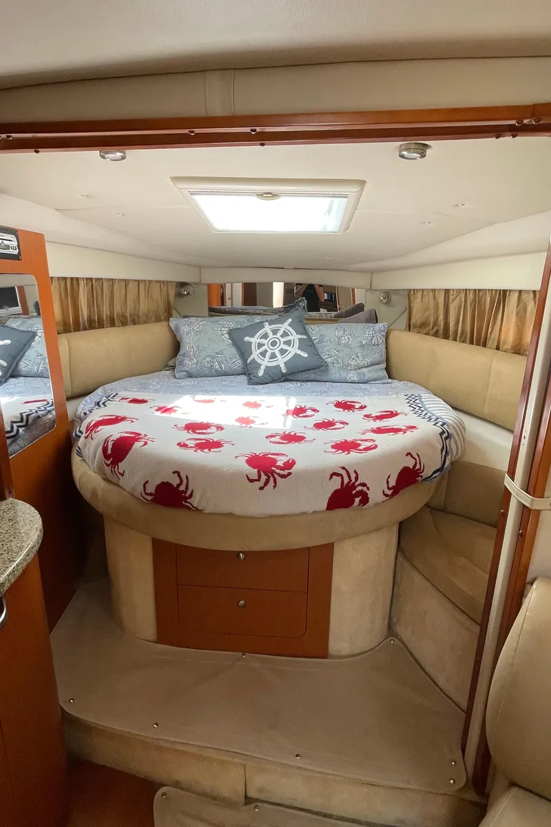 Slide: The Image of 2005 Chaparral Signature 350 cabin with round bed, nautical decor, and crab-themed bedding. - 26