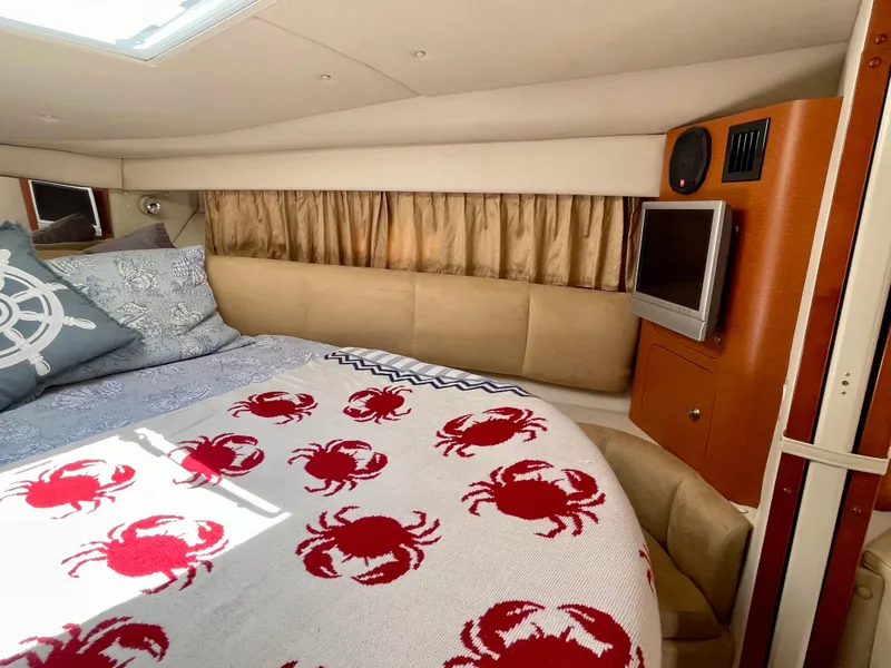Slide: The Image of Interior of 2005 Chaparral Signature 350 with cozy bed and nautical-themed decor. - 28