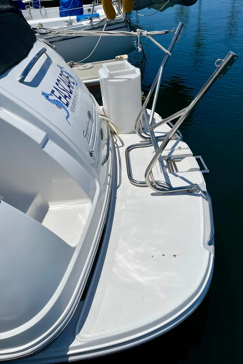 Slide: The Image of 2005 Chaparral Signature 350 boat docked, featuring a sleek white exterior and swim platform. - 7