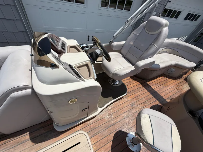 Slide: The Image of 2014 Avalon 2585 Catalina Bar interior with helm and seating on wooden deck. - 19