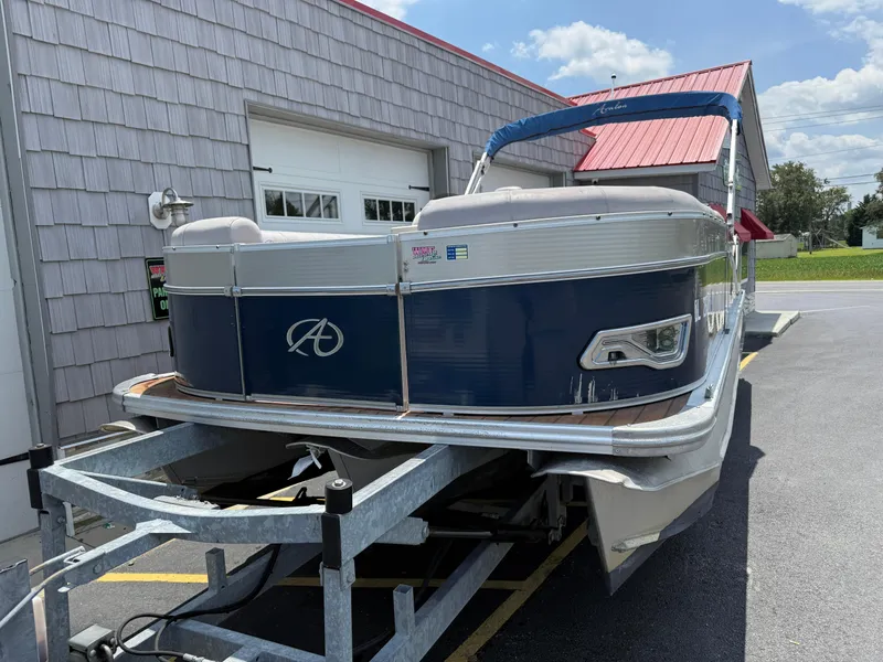 Slide: The Image of 2014 Avalon 2585 Catalina Bar Tri Toon boat on trailer, parked outside a building. - 5
