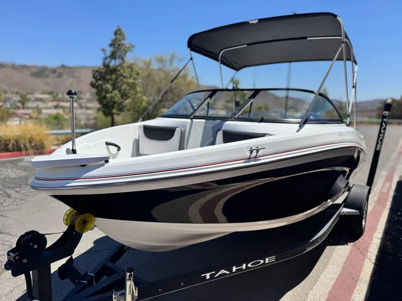 Slide: The Image of 2019 Tracker Tahoe 450 TF boat on trailer, parked outdoors with canopy. - 3