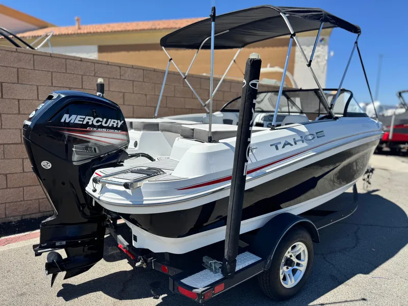 Slide: The Image of 2019 Tracker Tahoe 450 TF boat with Mercury engine, parked outdoors. - 5