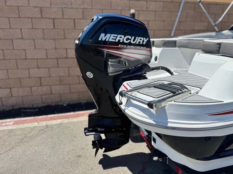 Slide: The Image of 2019 Tracker Tahoe 450 TF boat with Mercury FourStroke engine, parked on pavement. - 6