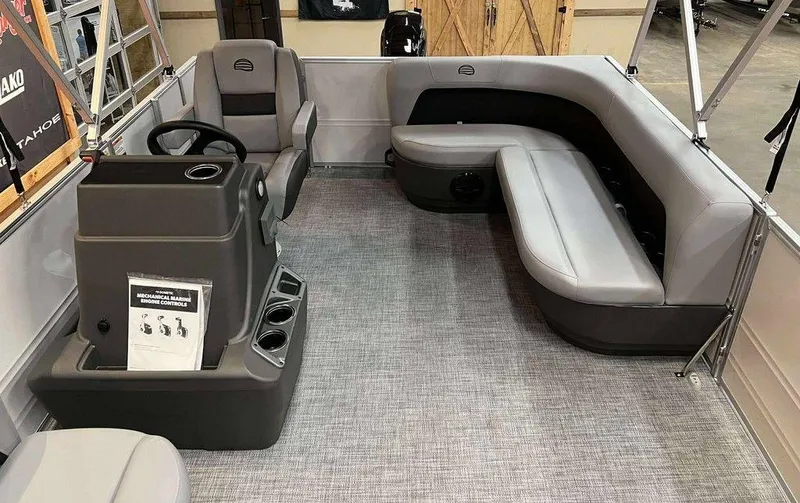 Slide: The Image of 2026 Sun Tracker PARTY BARGE® 16 DLX interior with gray seating and control console. - 5