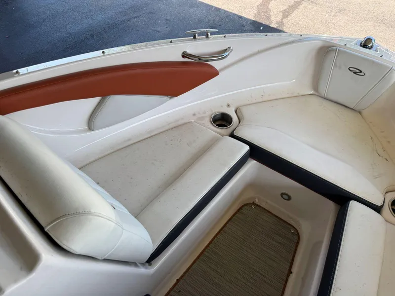 Slide: The Image of 2018 Regal 1900 ESX Bowrider interior with white and brown seating, cup holders, and storage. - 17