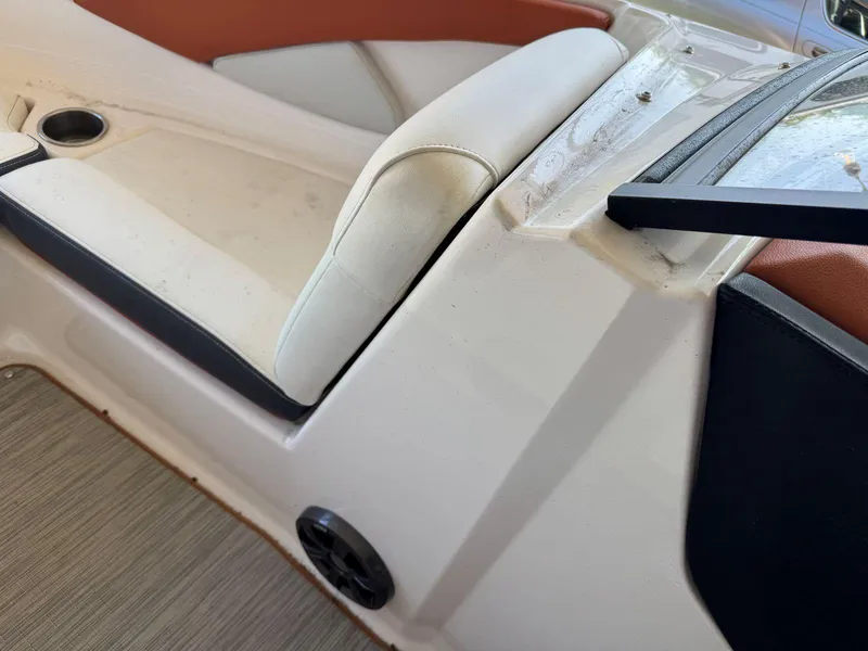 Slide: The Image of 2018 Regal 1900 ESX Bowrider interior with white and brown seating, cup holder, and speaker. - 19