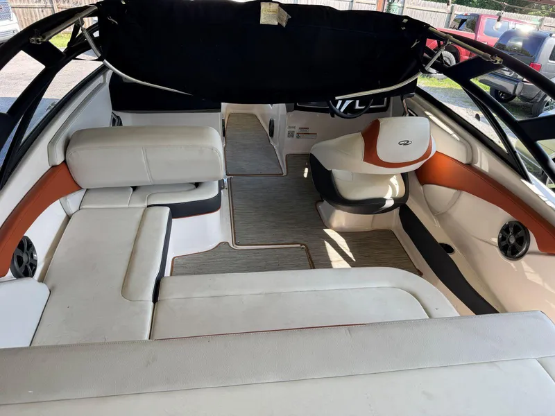 Slide: The Image of 2018 Regal 1900 ESX Bowrider interior with white and orange seating, black canopy, and modern design. - 4