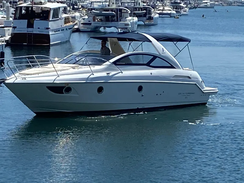 The Image of 2016 Beneteau GT35 yacht cruising in a marina with other boats in the background. - 0
