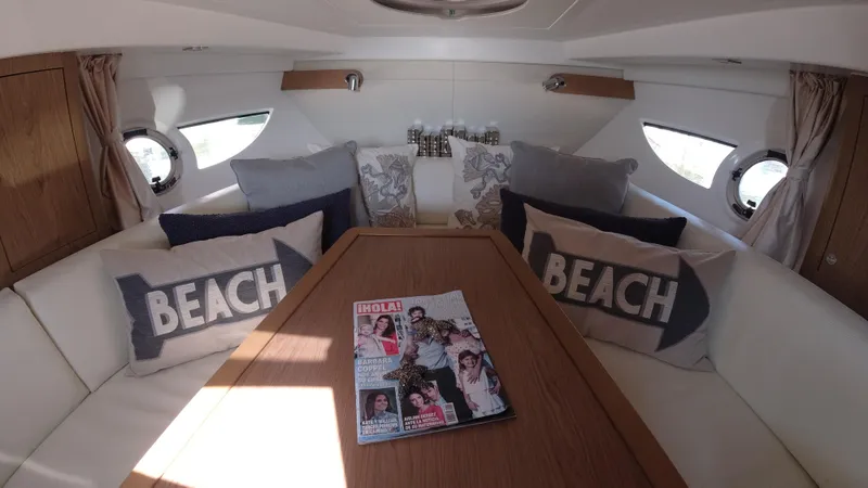 Slide: The Image of Interior of 2016 Beneteau GT35 yacht with cozy seating and beach-themed pillows. - 26