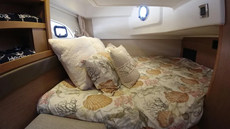 Slide: The Image of Cozy bedroom in 2016 Beneteau GT35 yacht with decorative pillows and porthole windows. - 30