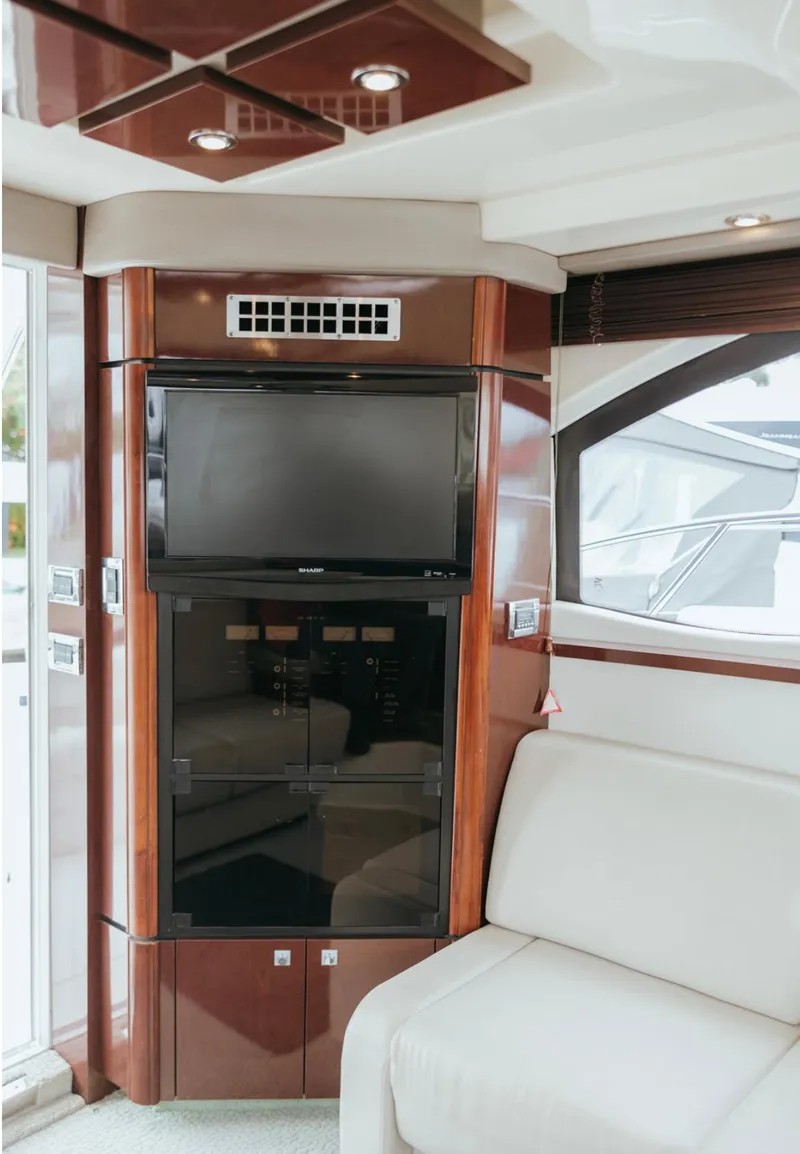 Slide: The Image of Luxurious interior of 2010 Sea Ray 390 Sedan Bridge with TV and elegant wood finish. - 14