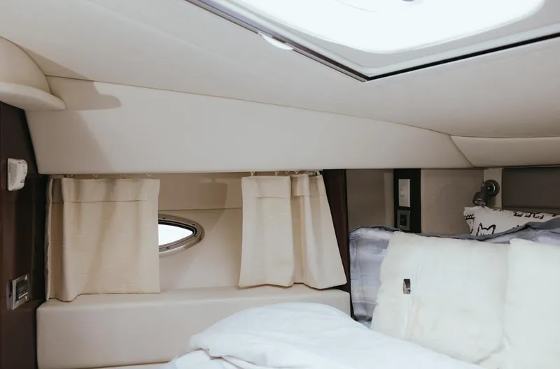 Slide: The Image of Interior cabin of 2010 Sea Ray 390 Sedan Bridge with cozy bedding and porthole window. - 18